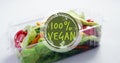 Image of 100 percent vegan text over box with fresh vegetables Royalty Free Stock Photo