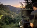 image of a person having a barbecue at sunset in nature concept of disconnection and enjoyment on vacation