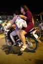 Image of Phnom Penh city at night. Couple riding a motorbike after buying food.