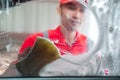 Image photo from inside the car cleaning car Asian man wearing uniform cleaning the side glass with a foamy sponge Royalty Free Stock Photo