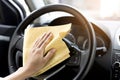 This image is a picture of a hand wiping the steering wheel with a microfiber cloth. Royalty Free Stock Photo