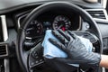 This image is a picture of wiping the car by a blue microfiber cloth with hand wearing gloves Royalty Free Stock Photo