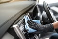 This image is a picture of wiping the car by a blue microfiber cloth with hand wearing gloves Royalty Free Stock Photo