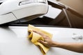 This image is a picture of wiping the car with a yellow microfiber cloth by hand. Royalty Free Stock Photo