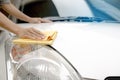 This image is a picture of wiping the car with a yellow microfiber cloth by hands. Royalty Free Stock Photo