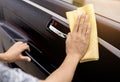 This image is a picture of wiping the car with a yellow microfiber cloth by hands. Royalty Free Stock Photo