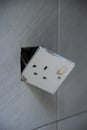 3-pin plug socket adapter hanging out from the wall Royalty Free Stock Photo