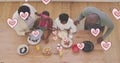 Image of pink hearts over happy african american grandparents and grandchildren cooking at home Royalty Free Stock Photo