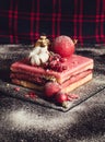 Image of pink punch cake dessert with christmas decor on rustic and dark background in christmas time - with powdered sugar