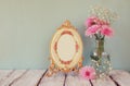 Image of pink and white flowers and antique frame on wooden table. template, ready to put photography