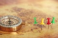 Image of pins attached to map, showing location or travel destination next to vintage compass. selective focus. Royalty Free Stock Photo