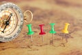 Image of pins attached to map, showing location or travel destination next to vintage compass. selective focus. Royalty Free Stock Photo