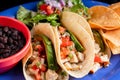 Image of a plate of tacos with salad and black beans