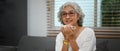 Image of pleasant middle aged woman relaxing on couch and enjoys her morning coffee. Retried lifestyle concept Royalty Free Stock Photo