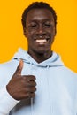 Image of pleased african american guy smiling and showing thumb up Royalty Free Stock Photo