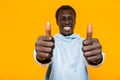 Image of pleased african american guy smiling and showing thumbs up Royalty Free Stock Photo