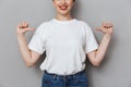 Image of pleased brunette woman smiling and pointing fingers at herself