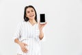 Image of pleased pregnant woman 30s with big belly smiling and holding smartphone in hand Royalty Free Stock Photo