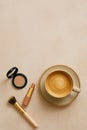 A flat lay arrangement features a beige background with a cappuccino in a ceramic cup and saucer Royalty Free Stock Photo