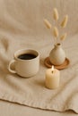 A cozy arrangement features a cream-colored ceramic mug filled with black coffee on a beige cloth surface Royalty Free Stock Photo