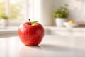 Single red apple with green leaf on countertop in softly lit kitchen Royalty Free Stock Photo
