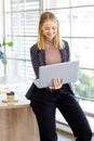 Image is portrait. Smiling beautiful Caucasian businesswomen standing and using laptop computer is working in the room at the Royalty Free Stock Photo