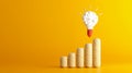 The image portrays a stack of coins representing financial growth, with a light bulb hovering above, symbolizing ideas Royalty Free Stock Photo