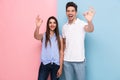 Image of positive couple in casual t-shirts smiling and gesturing ok sign, isolated over colorful background