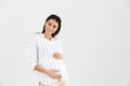 Image of positive pregnant woman 30s smiling and touching her big tummy