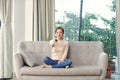 Image of a positive smiling optimistic young woman sit indoors at home watch tv holding remote control on sofa