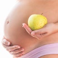 Image of pregnant woman touching her big belly and holding green apple in the hand isolated on white background. Royalty Free Stock Photo