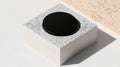 A black circular object sits atop a stack of white and gray blocks. Royalty Free Stock Photo
