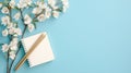 A light blue background with a white notebook, pencils, and flowers. Royalty Free Stock Photo