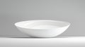 A white bowl with a smooth, curved rim sits on a white surface against a gray background. Royalty Free Stock Photo