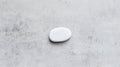 A white pebble sits on a gray concrete surface. Royalty Free Stock Photo