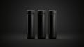 Three identical black cylindrical containers with black caps. Royalty Free Stock Photo
