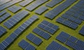 grid numerous solar panels arranged in diamond pattern, with vibrant green field in the background. Royalty Free Stock Photo