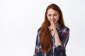 Image of pretty caucasian girl with red hair smiles, make shush, press finger to lips, quiet or taboo gesture, hushing Royalty Free Stock Photo