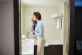 Pretty female in formal wear looking at mirror while washing hands in bathroom Royalty Free Stock Photo