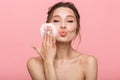 Pretty young woman posing isolated over pink wall background holding powder puff Royalty Free Stock Photo