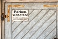 private no parking sign with german text Illegally parked vehicles will be towed at the owner's expense