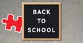 Image of puzzles falling over back to school text on black letter board