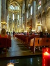 Image from rear of cathedral with burning candles while religious service being conducted Royalty Free Stock Photo