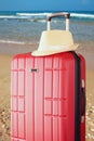 Image of red elegant travel luggage and fedora hat in front of sea. travel and vacation concept Royalty Free Stock Photo