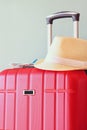 Image of red elegant travel luggage and fedora hat in front of sea. travel and vacation concept Royalty Free Stock Photo