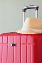 Image of red elegant travel luggage and fedora hat in front of sea. travel and vacation concept Royalty Free Stock Photo