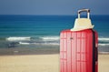 Image of red elegant travel luggage and fedora hat in front of sea. travel and vacation concept Royalty Free Stock Photo