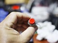 Image of a red push button switch held in a person's hand Royalty Free Stock Photo