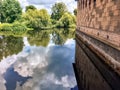 Reflection of a castle and a forest, on a lake that surrounds them