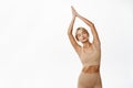 Image of relaxed and peaceful young fitness girl, doing yoga workout, posing in sportsbra against white studio